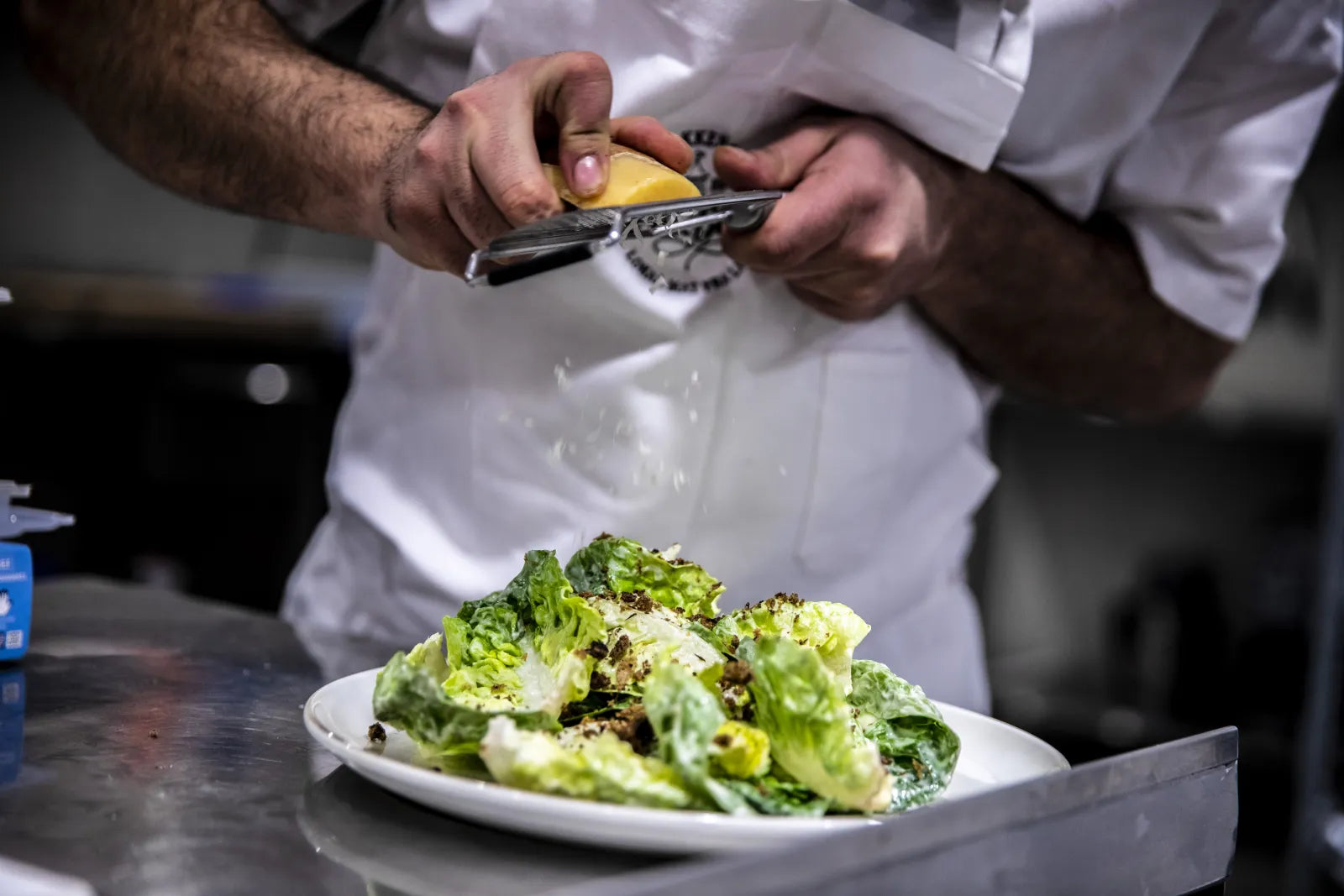 Kokken river fersk ost over salat